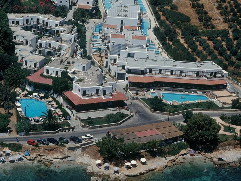 Complesso alberghiero sul mare con piscine, ombrelloni e accesso diretto alla spiaggia.
