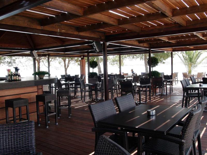 Terrazza coperta con mobili in legno e vista mare, ideale per un soggiorno rilassante.