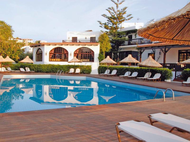 Piscina dell'hotel invitante con lettini e ombrelloni di paglia in un ambiente soleggiato.