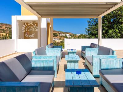 Espace de détente extérieur moderne avec mobilier rembourré bleu sous une pergola par ciel clair