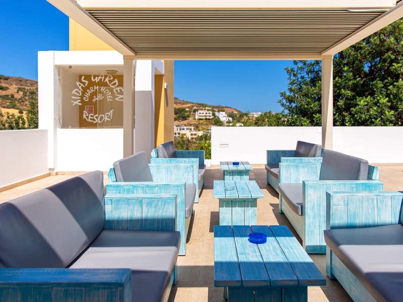 Espace de détente extérieur moderne avec mobilier rembourré bleu sous une pergola par ciel clair