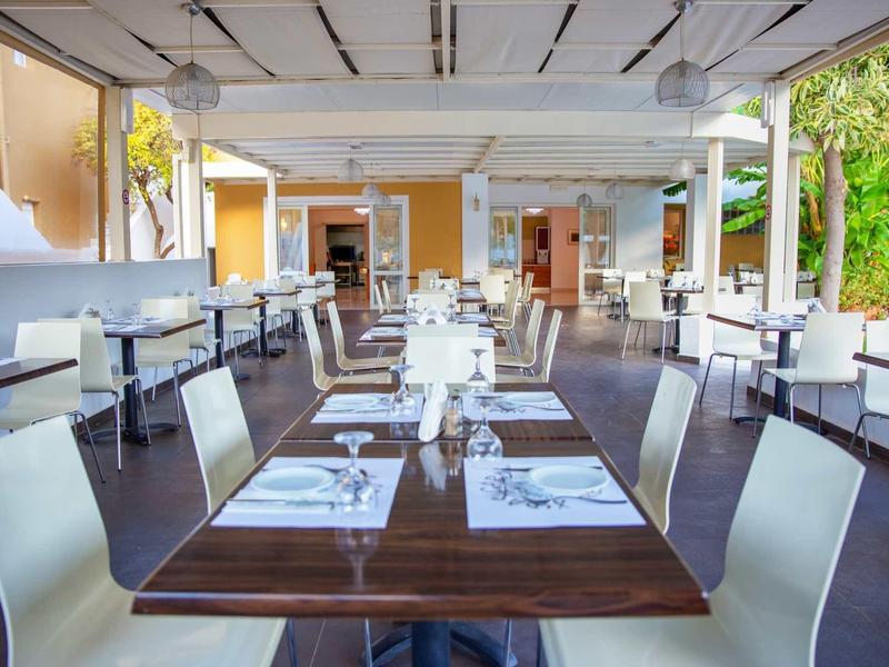 Restaurant moderne et ouvert avec des tables et chaises élégantes prêtes pour les invités.