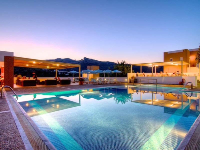 Piscine extérieure moderne sur une terrasse avec vue sur la montagne au coucher du soleil.