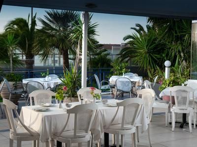 Elegant restaurant with white tablecloths and tropical plants in the background