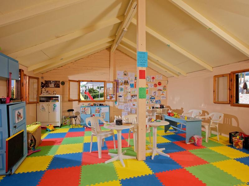 Colorful children's playroom with toys and windows, bright and inviting.
