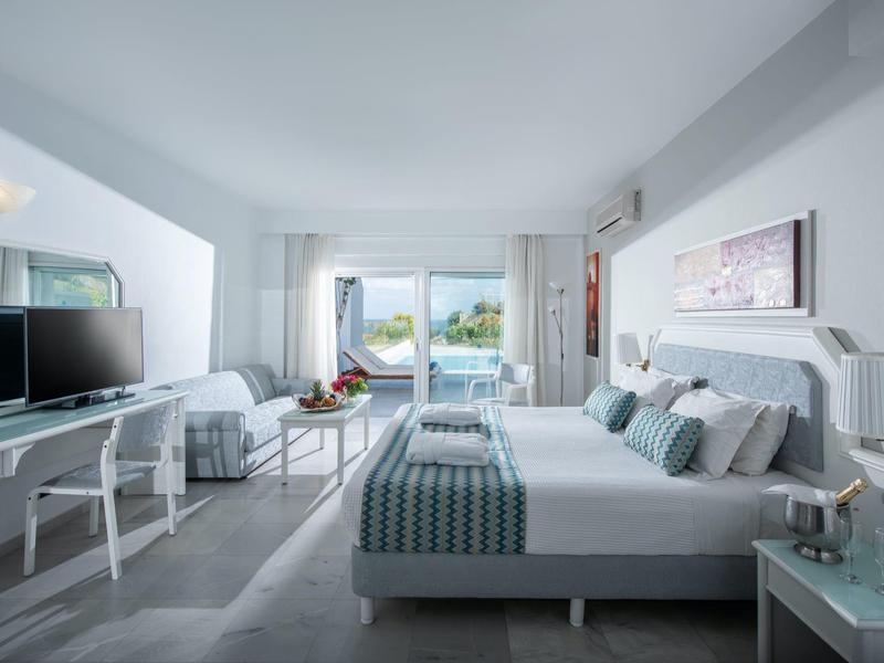 Modern hotel room with double bed and sea view from the balcony.