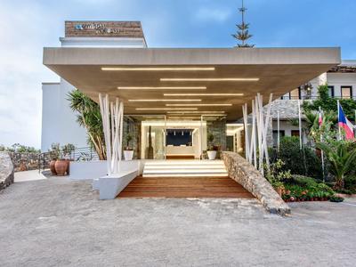 Ingresso moderno dell'hotel con ampio tettoia e design simmetrico alla luce del giorno.