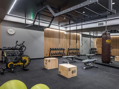 Palestra moderna con attrezzature da allenamento, pesi, sacco da boxe e casse di legno su pavimento nero