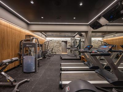 Palestra moderna con tapis roulant e macchine per la forza in un hotel.