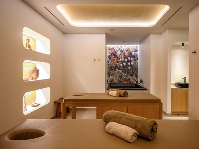 Camera benessere moderna con lettini da massaggio, illuminazione soffusa e decorazioni murali