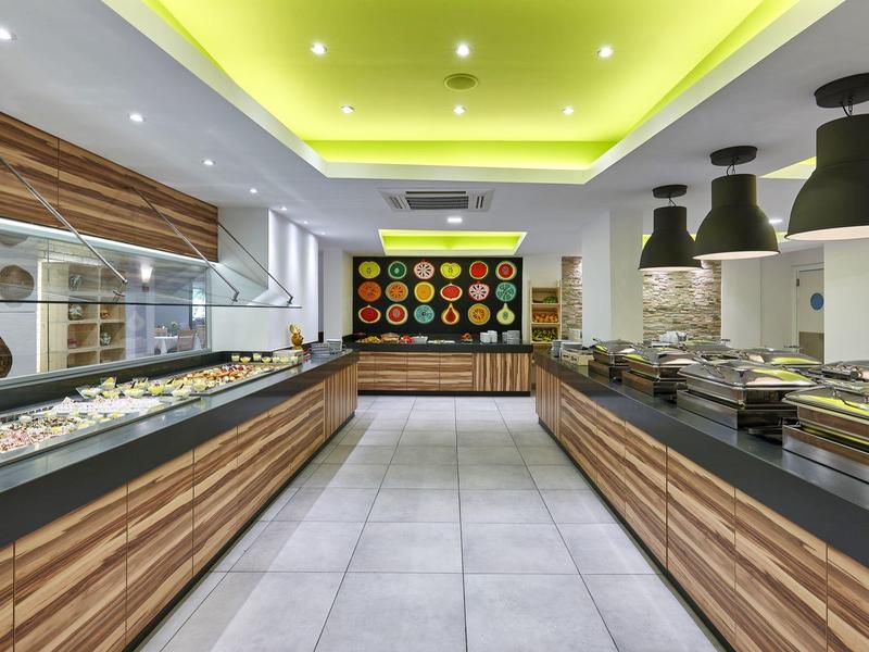 Buffet moderno con accenti in legno, pavimento chiaro e illuminazione decorativa a parete.