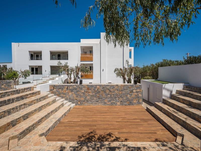 Edificio dell'hotel bianco con più balconi e scale in un'area esterna soleggiata.