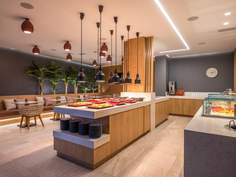 Buffet moderno in hotel con vari piatti e aree salotto accoglienti.