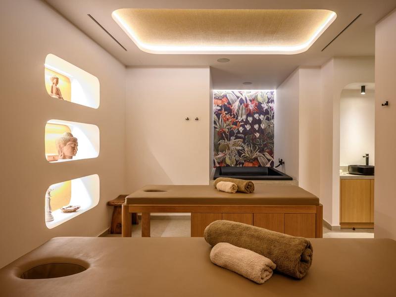 Camera benessere moderna con lettini da massaggio, illuminazione soffusa e decorazioni murali