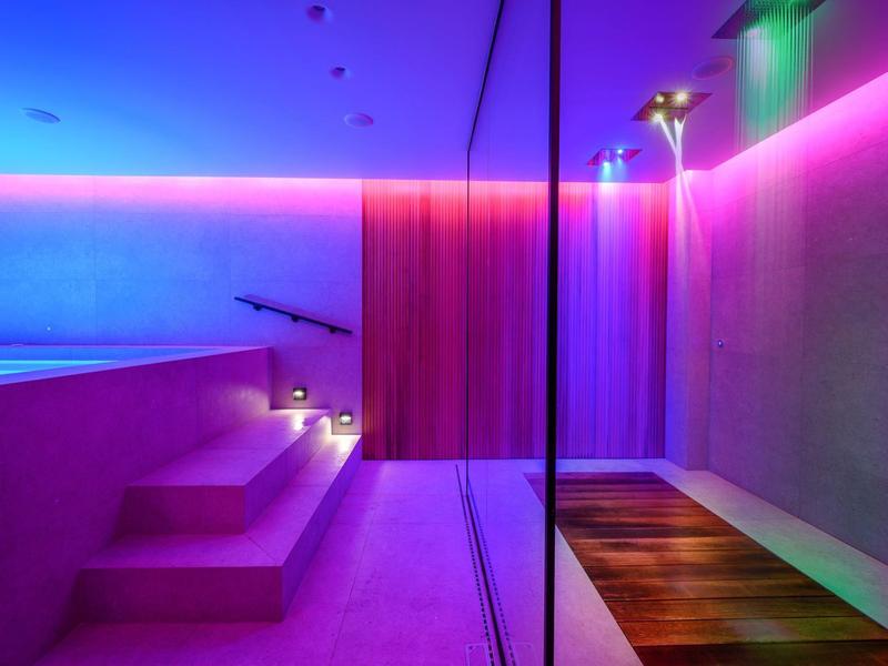 Bagno spa moderno con vasca idromassaggio, doccia e illuminazione LED colorata