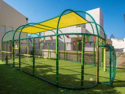 Moderno canestro da basket coperto su campo sportivo verde con cielo azzurro
