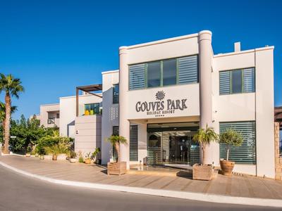 Nowoczesny budynek hotelu z białą elewacją i palmami pod czystym niebieskim niebem