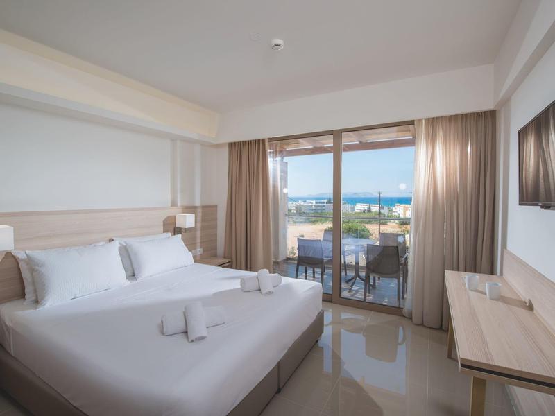 Camera d'hotel moderna con letto matrimoniale e balcone con vista mare