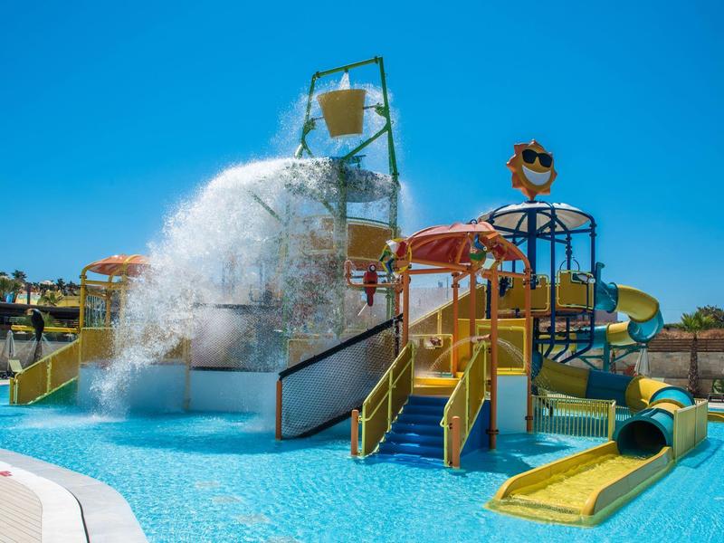 Parco acquatico con grandi scivoli d'acqua e un enorme secchio che versa acqua sulla piscina.