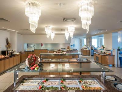 Un buffet moderno con varie insalate e condimenti in un'area pranzo luminosa.