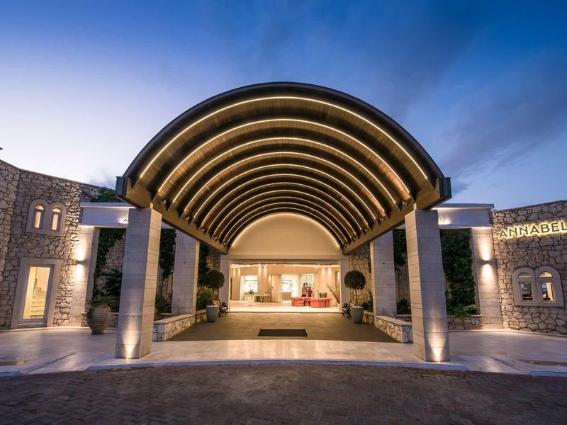 Atrio d'hotel moderno con grande pensilina ad arco e ingresso accogliente.