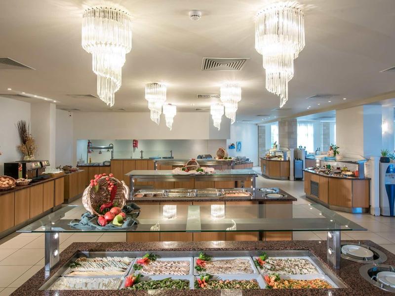 Un buffet moderno con varie insalate e condimenti in un'area pranzo luminosa.