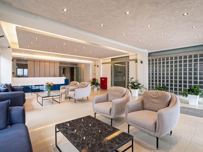 Modern eingerichteter Hotel-Loungebereich mit Sesseln, Sofas und einem Couchtisch.