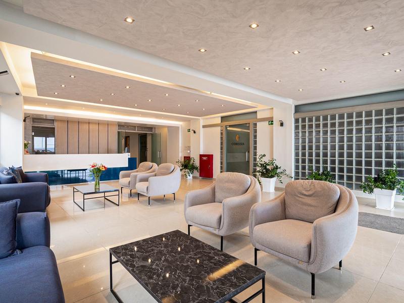 Modern eingerichteter Hotel-Loungebereich mit Sesseln, Sofas und einem Couchtisch.