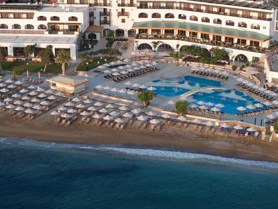 Hotelanlage mit großem Pool und vielen Sonnenschirmen am Strand
