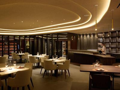 Modernes Restaurant mit stilvoller Beleuchtung, bequemen Stühlen und elegant gedeckten Tischen.