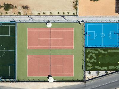 Vista aerea di due campi da tennis e un campo da basket accanto a un campo da calcio.