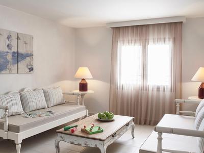 Salon lumineux avec canapé, fauteuils et table basse décorative avec des pommes.