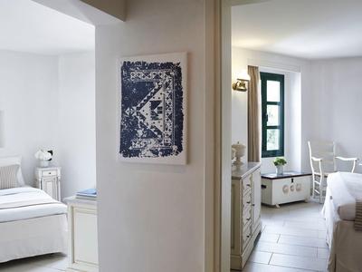 Chambre d'hôtel moderne avec murs blancs et décoration simple.