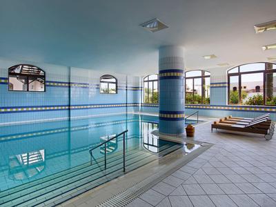 Vue intérieure d'une piscine intérieure avec chaises longues et grandes fenêtres