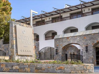 Vista esterna di un hotel con facciata bianca e insegna in pietra con il nome dell'hotel.