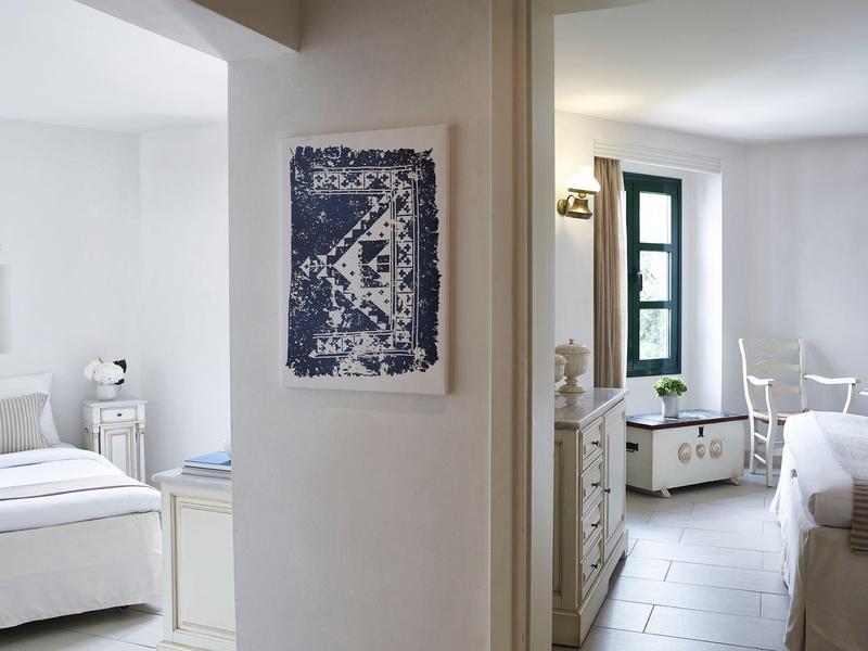 Chambre d'hôtel moderne avec murs blancs et décoration simple.