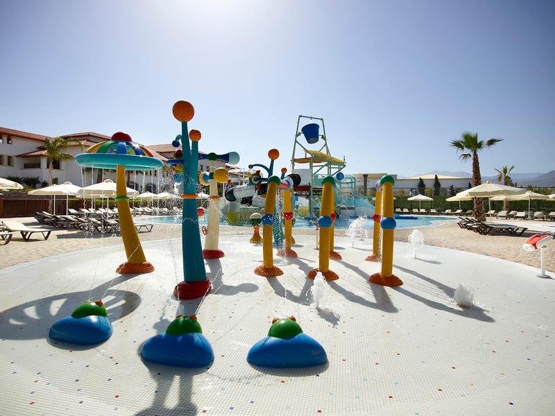 Aire de jeux aquatique colorée en plein air dans un hôtel sous un ciel ensoleillé