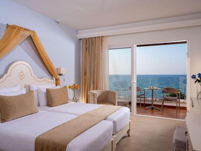 Modernes Hotelzimmer mit zwei Einzelbetten und Balkon mit Meerblick