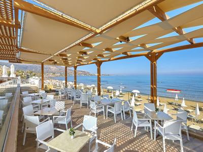Terrazza aperta con sedie e tavoli bianchi vista mare con tenda