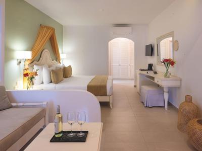 Jasny pokój hotelowy z dużym łóżkiem, sofą, biurkiem i relaksującą atmosferą