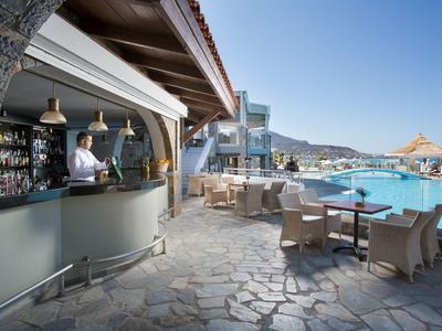 Bar obok basenu z miejscami do siedzenia i czystym niebem w ośrodku hotelowym.