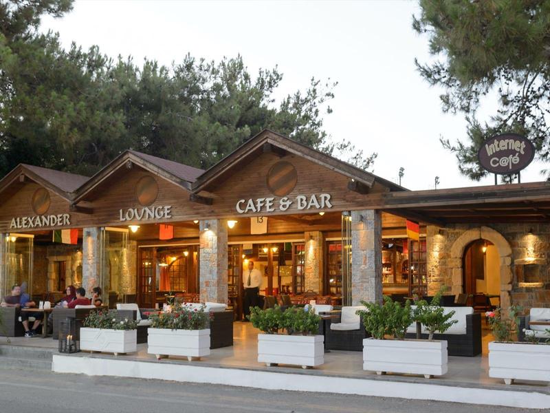 Widok na przytulną kawiarnię z tarasem i miejscami do siedzenia na zewnątrz.