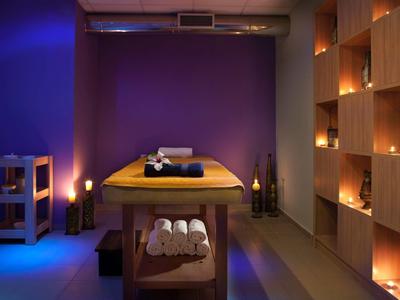 Une salle de massage relaxante avec un éclairage doux et des serviettes sur la table.