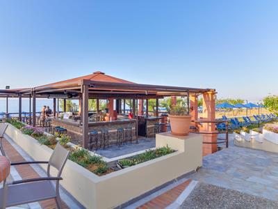 Padiglione aperto con aree salotto accanto a vista mare e ombrelli da sole all'aperto