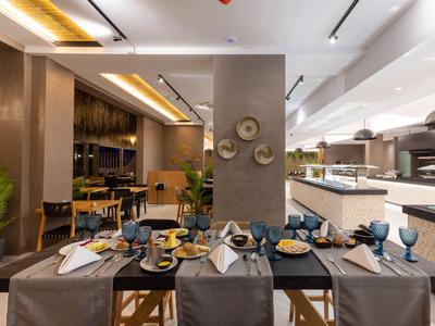 Modernes Restaurant mit gedeckten Tischen und offenem Küchenbereich.