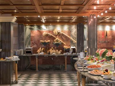 Buffet im Restaurant mit einer Auswahl an Gerichten und einem kunstvoll gestalteten Decken- und Wandbereich.