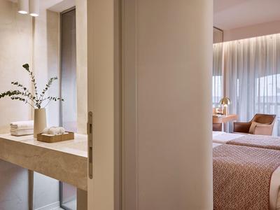 Pasillo moderno de habitación de hotel con consola de madera pulida y plantas decorativas.