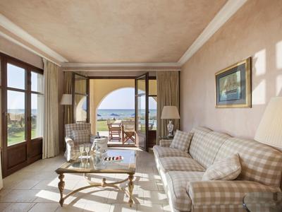 Helles Wohnzimmer in einem Hotel mit Zugang zu einer Terrasse und Meerblick.