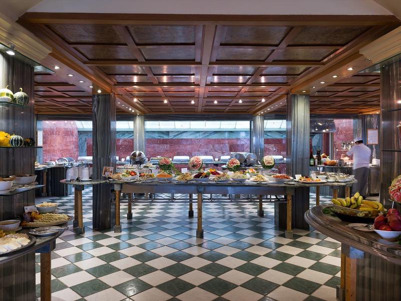 Eleganter Buffetbereich mit vielfältigen Speisen und schwarz-weiß kariertem Boden.