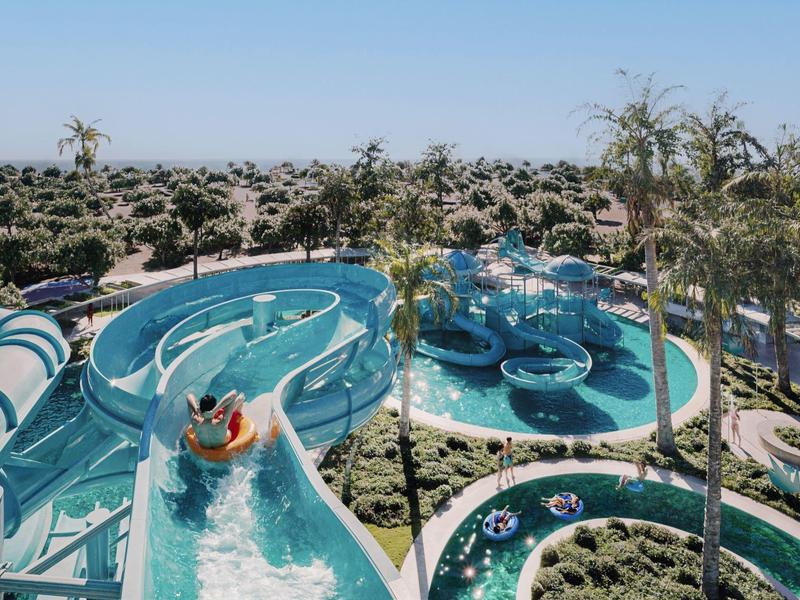 Wasserpark mit mehreren Wasserrutschen und Palmen im sonnigen Urlaubsort.